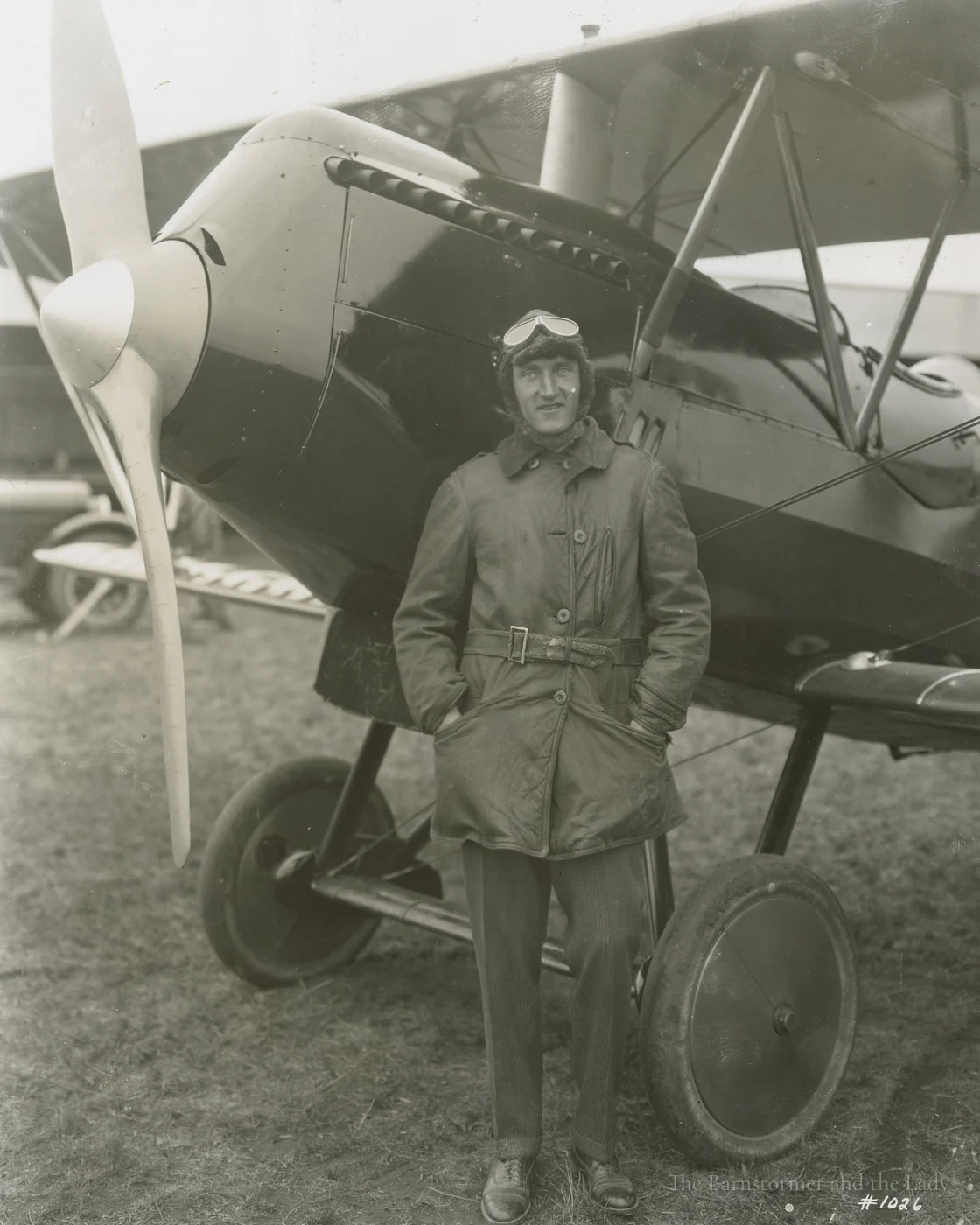Walter Beech in flying gear standing in front of a biplane